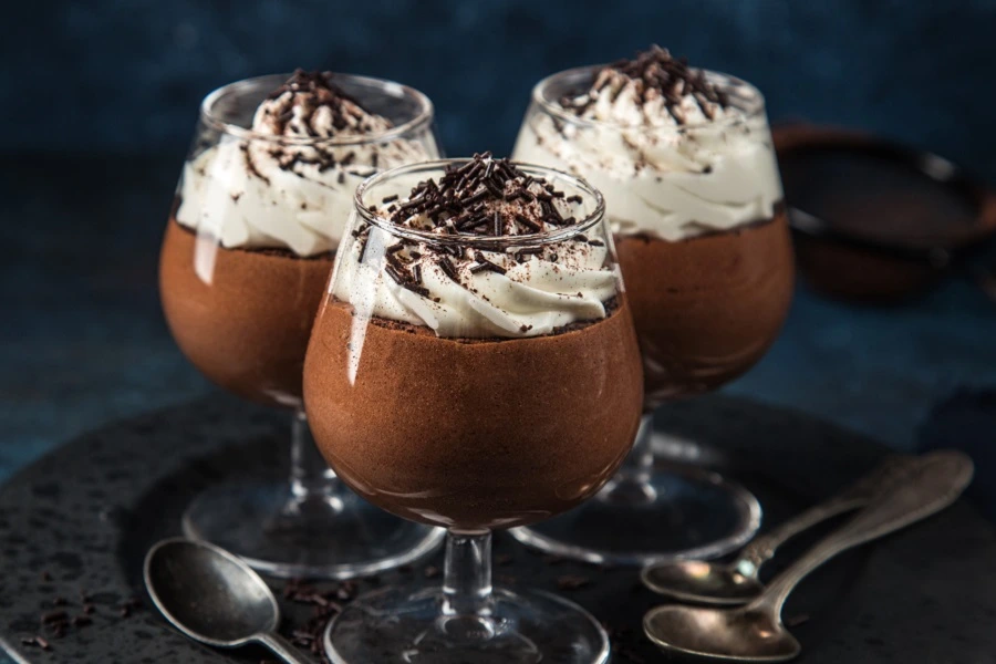 chocolate mousse with whipped cream in three glasses